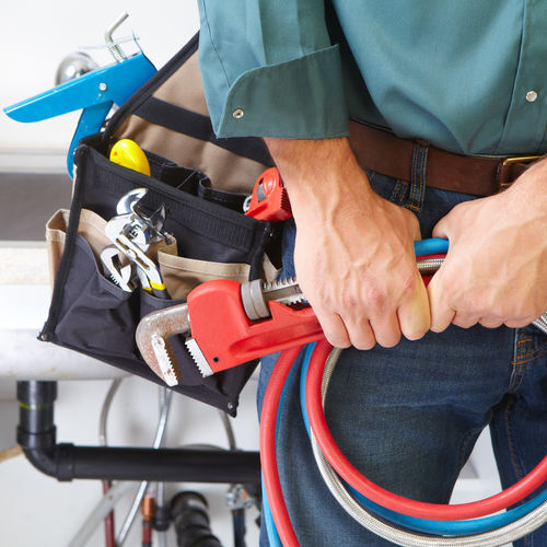 Plumber with Plumbing tools on the kitchen. Renovation.