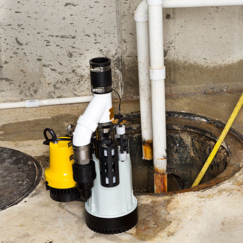 Replacing the old sump pump in a basement with a new one to drain the collected ground water from the sump or pit