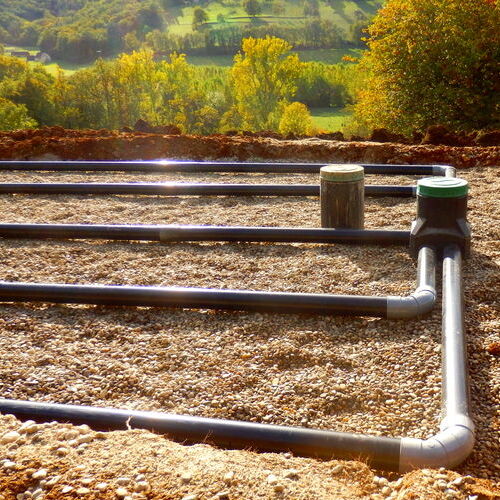 the top layer of pipework, after the membrane, sand and gravel had been applied, during the construction of a sand and gravel drainage system
